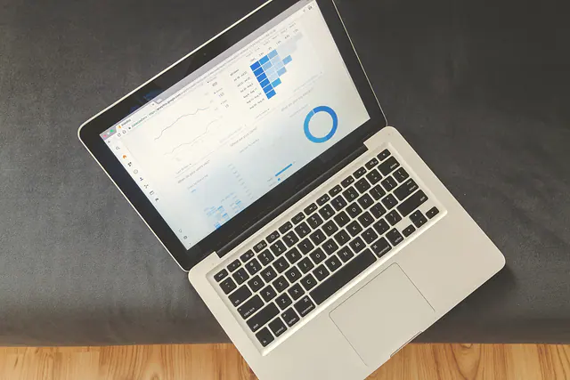 Overhead view of a laptop showing an analytics dashboard with charts.